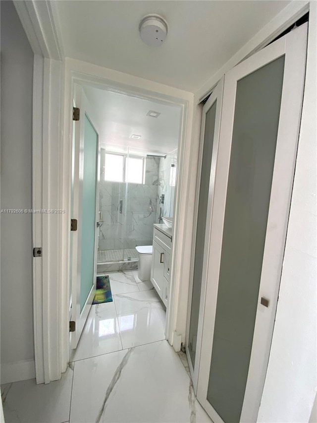 1700 NW N River Dr Unit 501, Miami, FL 33125 - full bathroom featuring vanity, toilet, a marble finish shower, marble finish floor, and baseboards