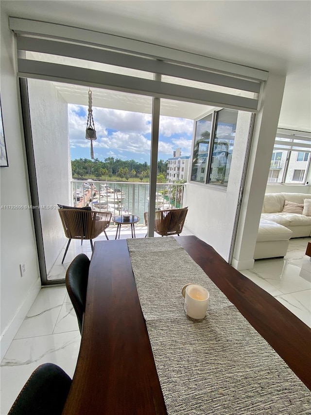 1700 NW N River Dr Unit 501, Miami, FL 33125 - dining room featuring baseboards, plenty of natural light, a water view, and marble finish floor