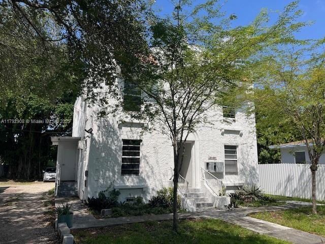view of front of house with fence and stucco siding