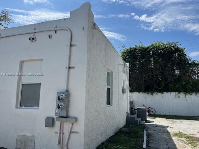view of side of home with central air condition unit and stucco siding