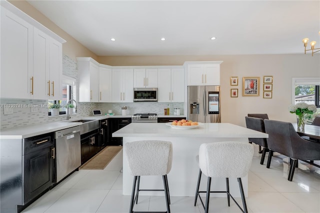 6470 SW 33rd St, Miami, FL 33155 - kitchen featuring stainless steel appliances, dark cabinetry, a sink, a breakfast bar, and white cabinetry