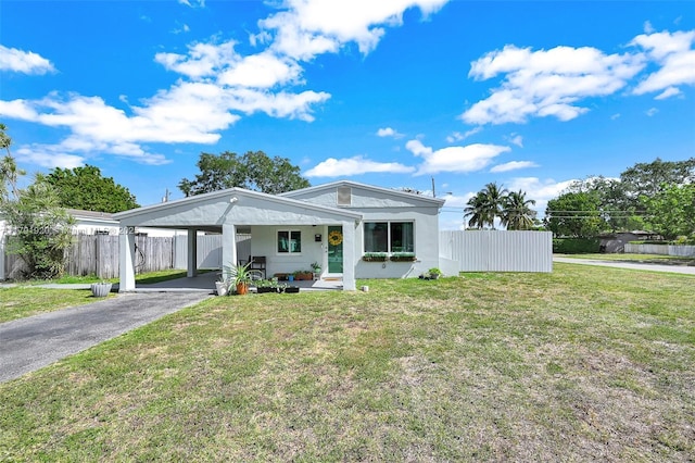 bungalow-style house featuring an attached carport, fence, and a front yard