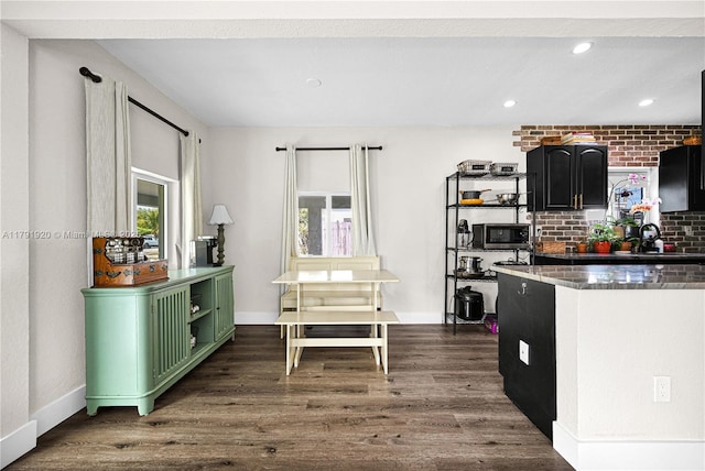 kitchen featuring dark wood-type flooring, a sink, green cabinetry, and stainless steel microwave