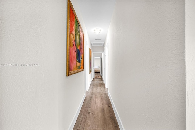 hall with baseboards and wood finished floors