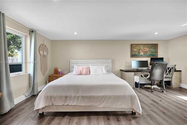 bedroom with baseboards, recessed lighting, and wood finished floors