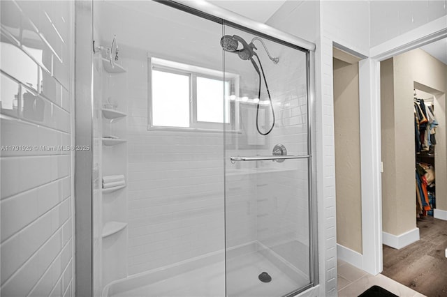 full bathroom with baseboards, wood finished floors, and a stall shower