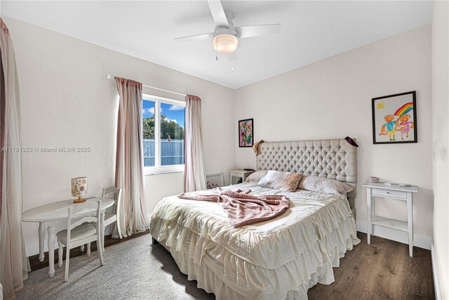 bedroom with a ceiling fan, baseboards, and wood finished floors
