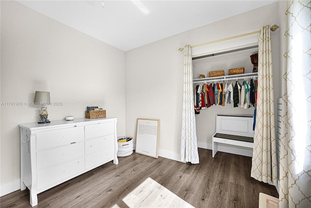 bedroom featuring baseboards, wood finished floors, and a closet