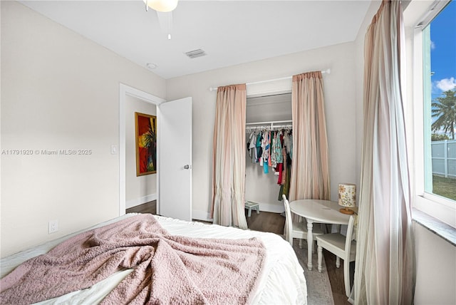 bedroom with a closet, wood finished floors, and visible vents