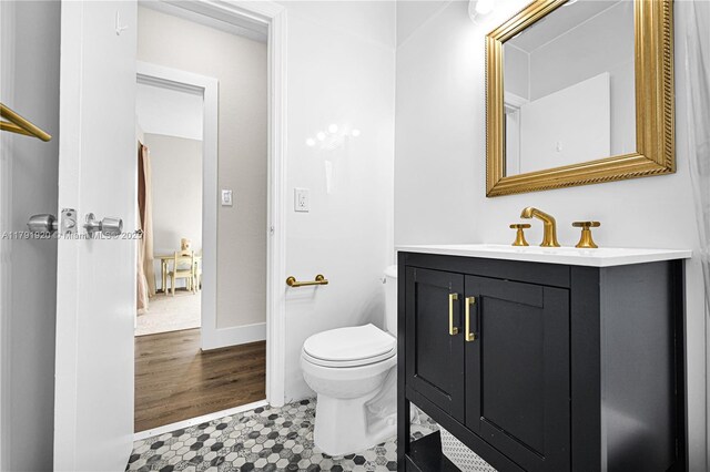 bathroom with vanity, baseboards, and toilet