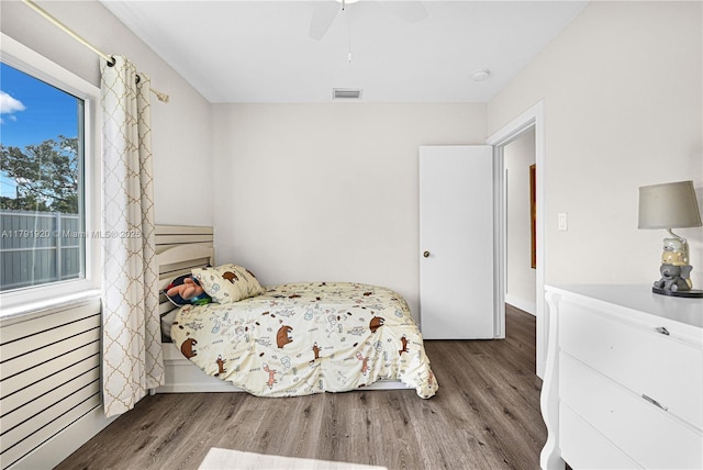 bedroom featuring ceiling fan, visible vents, and wood finished floors