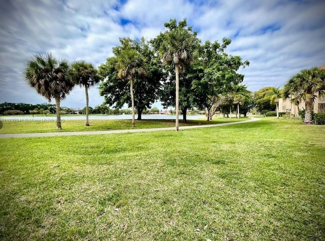 view of home's community featuring a water view and a yard