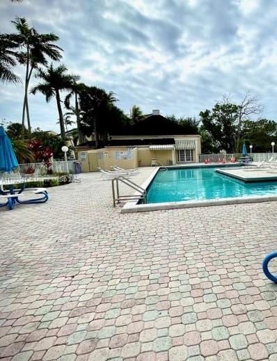 community pool with a patio and fence
