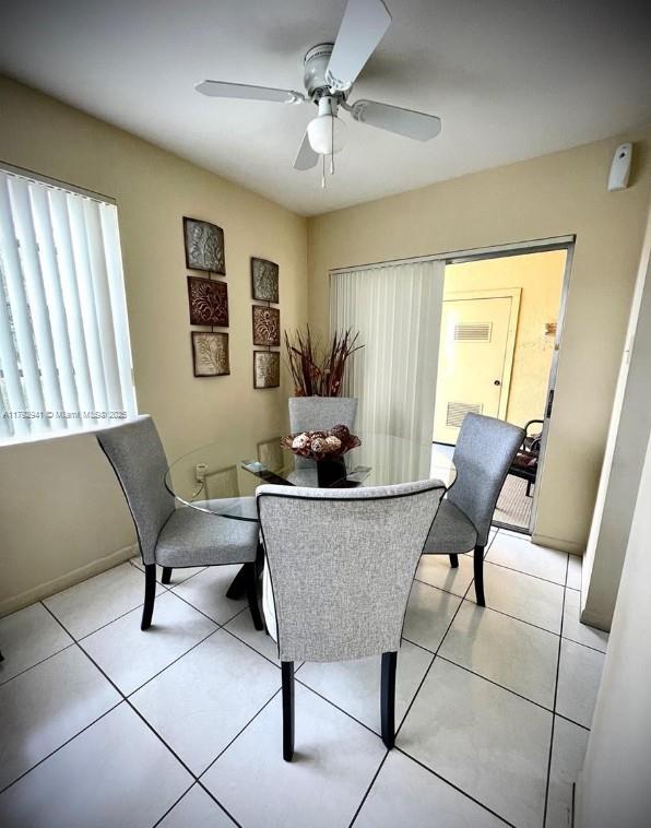 dining room with light tile patterned floors, baseboards, and ceiling fan