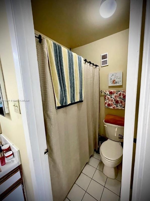 bathroom featuring toilet, visible vents, and tile patterned flooring