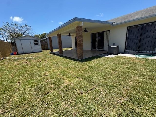 13333 SW 112th Pl, Miami, FL 33176 - rear view of property featuring a lawn, ceiling fan, a patio area, and a shed