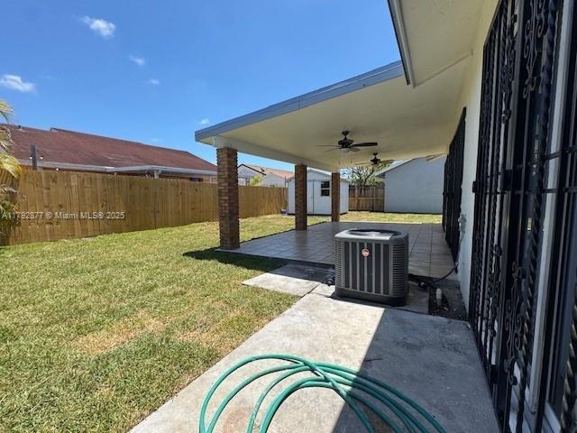 13333 SW 112th Pl, Miami, FL 33176 - view of yard with a fenced backyard, a shed, a ceiling fan, central air condition unit, and an outbuilding