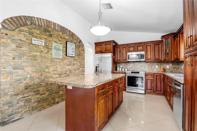 kitchen with light stone countertops, visible vents, stainless steel appliances, tasteful backsplash, and vaulted ceiling