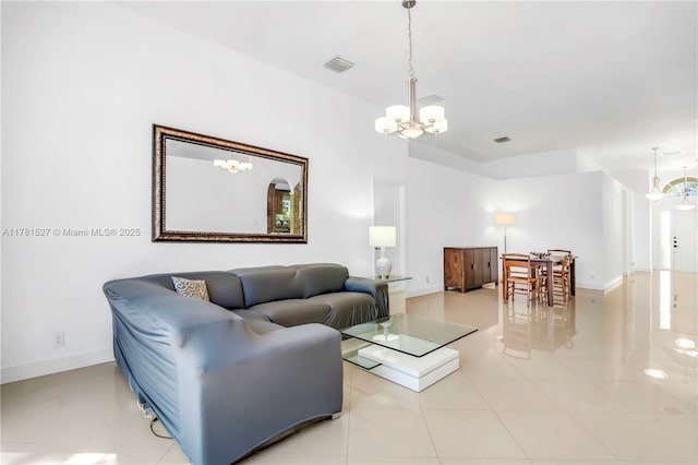 tiled living area with baseboards, a chandelier, and visible vents