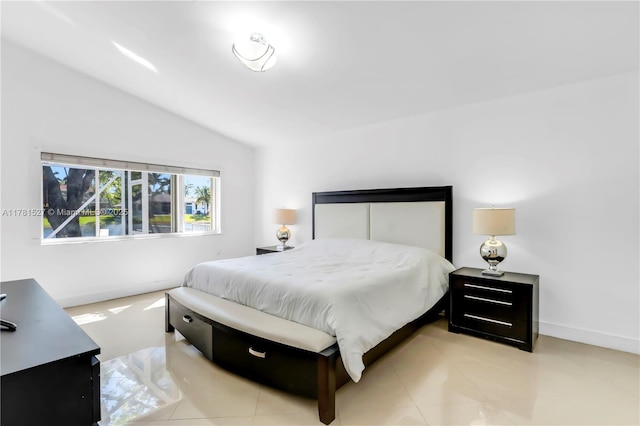 bedroom with baseboards and lofted ceiling