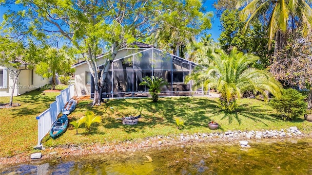 rear view of house featuring a lawn and a lanai