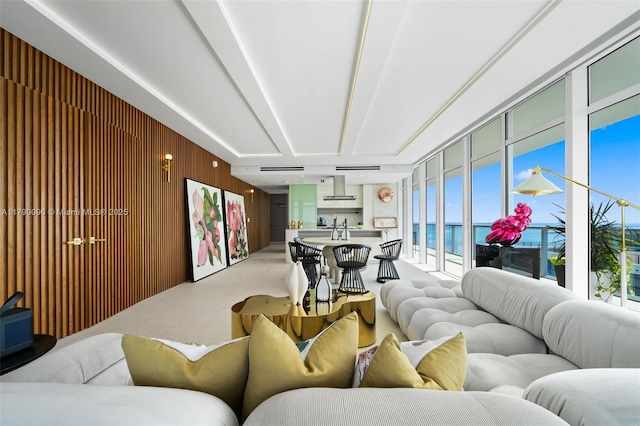 3737 Collins Ave Unit S-1303, Miami Beach, FL 33140 - living room featuring wood walls, floor to ceiling windows, light colored carpet, and a water view