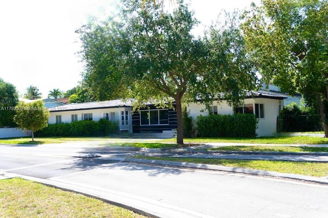 view of front facade with a front lawn and stucco siding