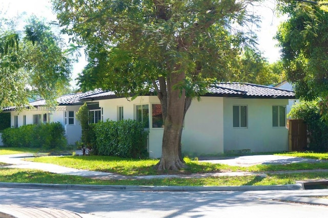 view of front facade with stucco siding and a tile roof