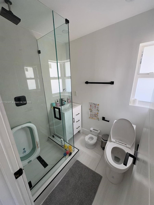 bathroom with vanity, toilet, a wealth of natural light, and a shower stall