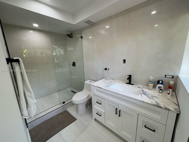 full bath featuring tile walls, toilet, visible vents, a walk in shower, and vanity