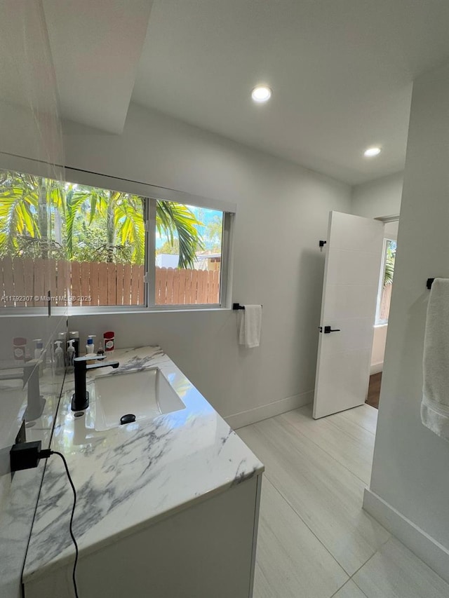 bathroom featuring recessed lighting, baseboards, and a sink