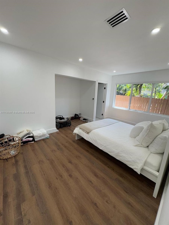 bedroom featuring wood finished floors, baseboards, visible vents, and recessed lighting