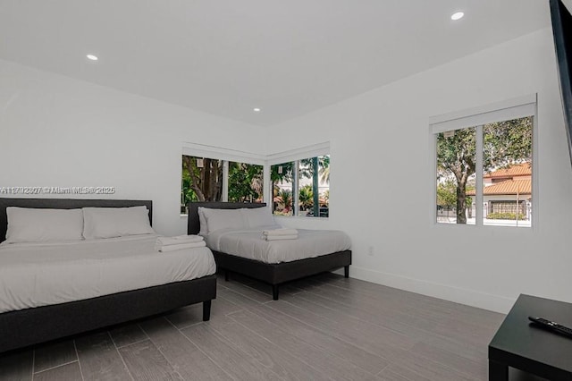 bedroom featuring recessed lighting, wood finished floors, and multiple windows
