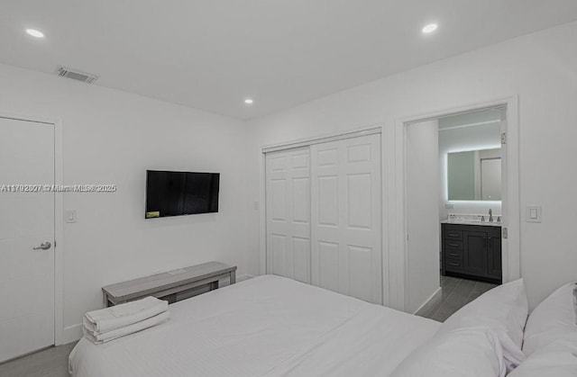 bedroom with a sink, a closet, ensuite bath, visible vents, and recessed lighting
