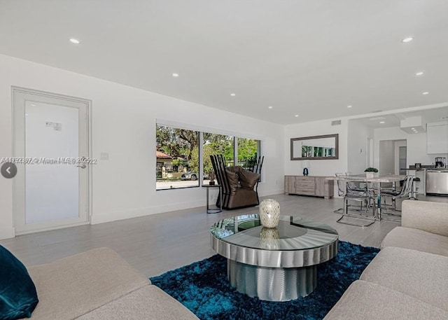 living room with recessed lighting, baseboards, visible vents, and wood finished floors