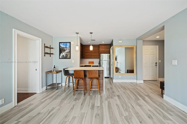 1770 E Las Olas Blvd Unit 507, Fort Lauderdale, FL 33301 - kitchen featuring freestanding refrigerator, light wood finished floors, a kitchen breakfast bar, a peninsula, and recessed lighting