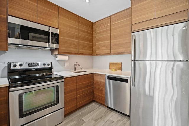 1770 E Las Olas Blvd Unit 507, Fort Lauderdale, FL 33301 - kitchen with appliances with stainless steel finishes, light countertops, a sink, and brown cabinetry