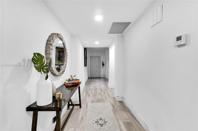 hall featuring visible vents, recessed lighting, baseboards, and light wood-type flooring