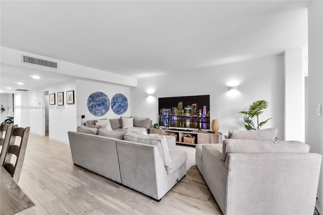 living room featuring recessed lighting, light wood-style flooring, and visible vents