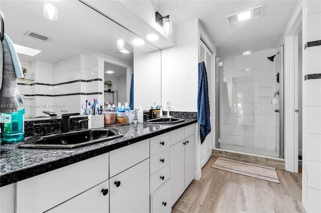 full bath featuring visible vents, a sink, and a stall shower