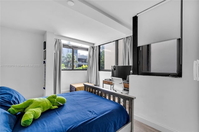 bedroom featuring baseboards and wood finished floors