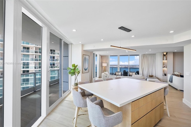 2127 Brickell Ave Unit 2704, Miami, FL 33129 - kitchen with light brown cabinetry, a large island, modern cabinets, a kitchen breakfast bar, and light wood finished floors
