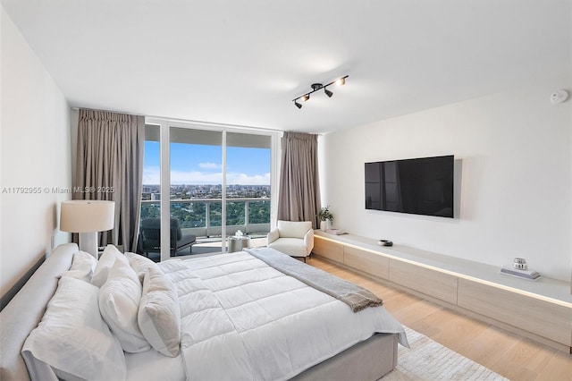2127 Brickell Ave Unit 2704, Miami, FL 33129 - bedroom with rail lighting, floor to ceiling windows, and wood finished floors