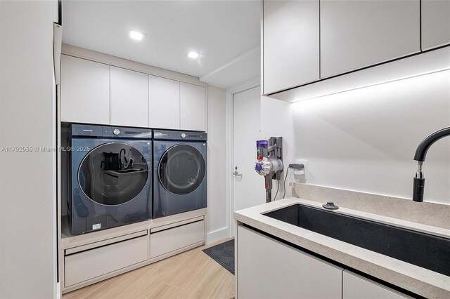 2127 Brickell Ave Unit 2704, Miami, FL 33129 - laundry room featuring washing machine and dryer, light wood-style floors, recessed lighting, a sink, and cabinet space