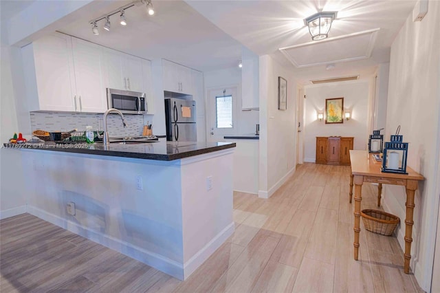 2751 N Palm Aire Dr Unit 310, Pompano Beach, FL 33069 - kitchen featuring stainless steel appliances, white cabinetry, a peninsula, and light wood-style floors