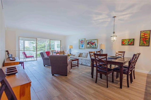 2751 N Palm Aire Dr Unit 310, Pompano Beach, FL 33069 - dining room featuring light wood finished floors, a chandelier, and baseboards