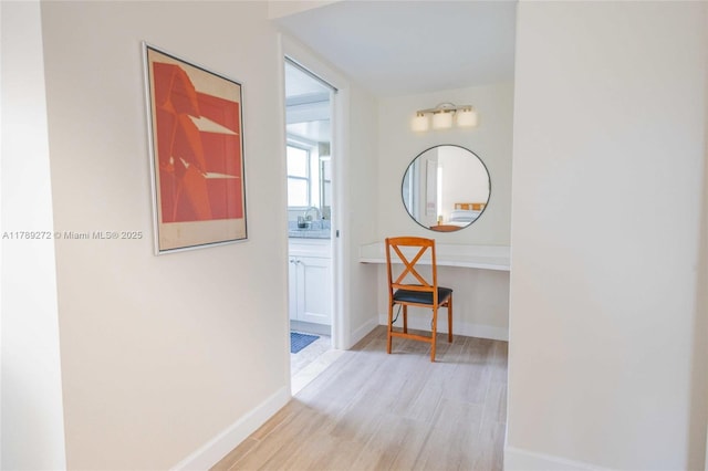 2751 N Palm Aire Dr Unit 310, Pompano Beach, FL 33069 - hall featuring light wood finished floors, baseboards, and a sink