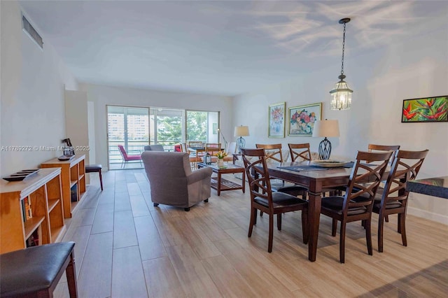 2751 N Palm Aire Dr Unit 310, Pompano Beach, FL 33069 - dining space with light wood-style flooring, a chandelier, and baseboards