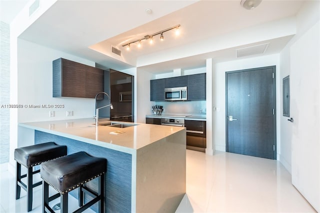 1080 Brickell Ave Unit 2504, Miami, FL 33131 - kitchen with stainless steel microwave, a sink, modern cabinets, and a breakfast bar area