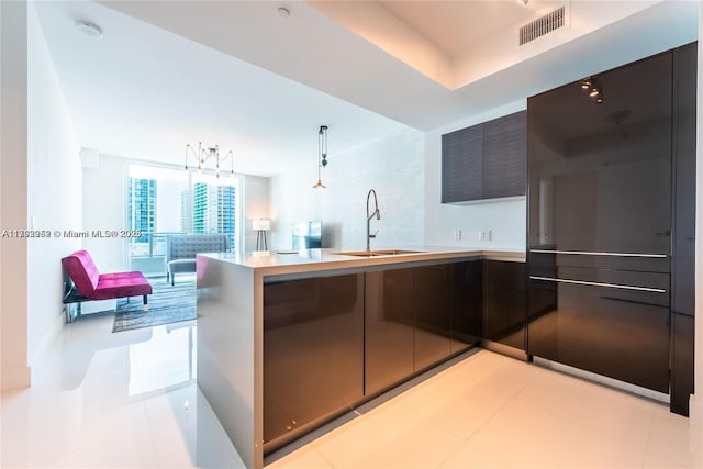1080 Brickell Ave Unit 2504, Miami, FL 33131 - kitchen featuring modern cabinets, a sink, light countertops, a peninsula, and decorative light fixtures